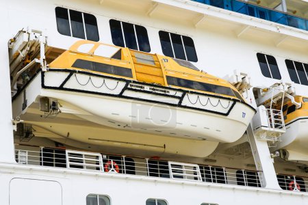 Photo for Side view of a large white cruise ship with hanging lifeboat, emergency rescue boat - Royalty Free Image