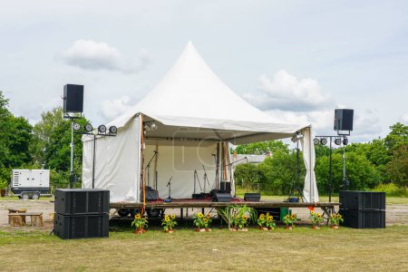 Eine kleine Bühne für Veranstaltungen im Freien für das Konzert vorbereitet, Stromversorgung aus einem Mietdiesel-Generator auf einem mobilen Anhänger