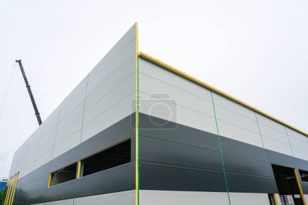 Foto de Nueva moderna fachada de edificio industrial de panel sándwich gris de dos tonos, nuevo edificio industrial, pared de paneles sándwich - Imagen libre de derechos