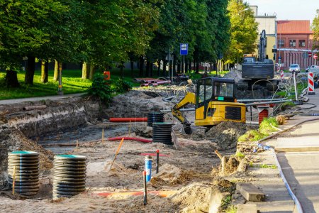 Photo for Street reconstruction view, replaced underground pipes, vertical plastic wells, dewatering system, excavators, deep and wide trench, digging works - Royalty Free Image