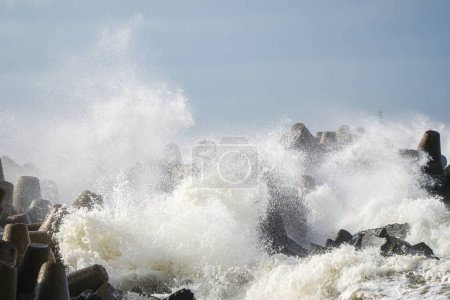 Photo for Storm at sea, high waves crashing against the concrete breakwaters of the port, white splashes, hurricane scene - Royalty Free Image