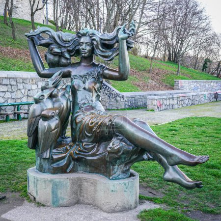 Téléchargez les photos : Bratislava, Slovaquie- 04 mars 2024 : Sculpture La Sorcière, statue de femme aux longs poils et corbeaux dans le parc à côté du château de Bratislava - en image libre de droit