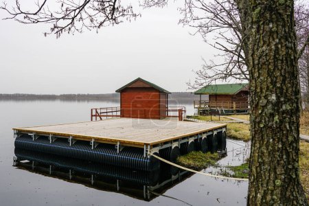 A new empty floating wooden platform on pontoons in the lake for the creation of a holiday and fishing house on the water