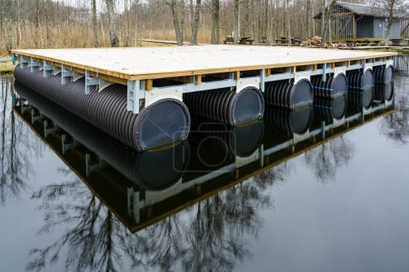 Une nouvelle plate-forme flottante en bois vide sur les pontons dans le lac pour la création d'une maison de vacances et de pêche sur l'eau