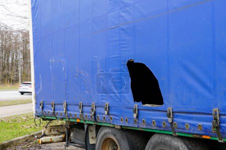 Photo for Truck trailer with blue damaged awning, cargo theft problem by cutting the awning, goods thefts from cargo trailers, goods stealing, cut awning - Royalty Free Image