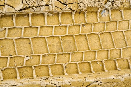 Profilabdrücke von Autoreifen im nassen gelben Sand, Radprotektor markiert Textur, Reifenspuren im Sand, Reifenabdrücke auf nasser sandiger Straße