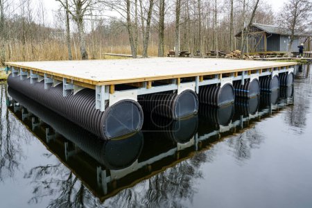 Une nouvelle plate-forme flottante en bois vide sur les pontons dans le lac pour la création d'une maison de vacances et de pêche sur l'eau