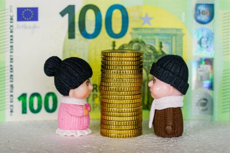 Hoher Stapel gelber Münzen zwischen Spielzeugfiguren älterer Männer und Frauen, Konzept für Geldstreitigkeiten, Konzept für finanzielle Unstimmigkeiten, Hintergrund für den Euro-Schein