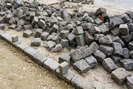 Street paving with historical hammered cubes shape granite paving stones, city street surface restoration, cubes rocks, cubes stones