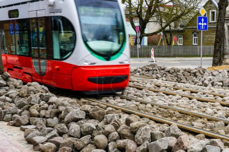 Eine moderne Niederflur-Straßenbahn fährt auf neu ersetzten Gleisen, unfertigen Pflasterarbeiten, Natursteinpflastersteinen
