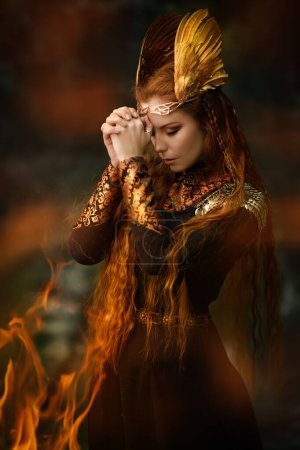 Porträt der göttlichen Kriegerin Walküre, die mit vor ihr gefalteten Händen auf dem Schlachtfeld betet, umhüllt von Feuerflammen. Epische Fantasie. Skandinavische Mythologie. 
