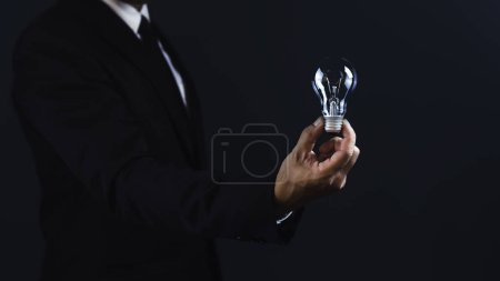 Businessman holding light bulb with empty space for design.