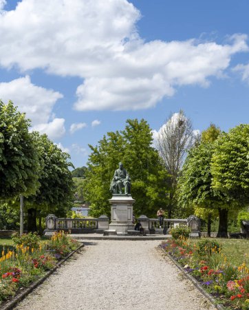 Téléchargez les photos : Arbois, France - July 17, 2020: Statue of Pasteur in the centre of Arbois with park on a summers day in the Jura, France. - en image libre de droit
