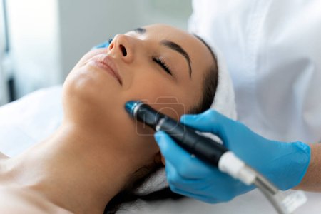 Photo for Close-up of woman getting facial hydro microdermabrasion peeling treatment. Female at cosmetic beauty spa clinic. Hydra vacuum cleaner. Cosmetology concept - Royalty Free Image