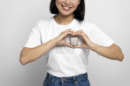 Foto de Vista recortada de la mujer que sostiene el desfibrilador automático implantable (DAI) en el fondo blanco. Cuidado de la salud y concepto del corazón - Imagen libre de derechos