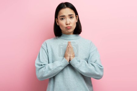 Photo for Portrait of attractive woman praying, begging with pleading grimace, gesture of asking apologising. Indoor studio shot isolated on pink background - Royalty Free Image