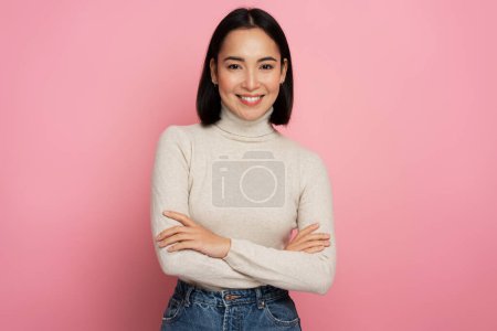 Portrait of pretty smiling happy woman looking at camera with cute positive face, being in good mood. Indoor studio shot isolated on pink background 