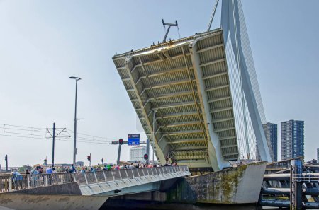 Téléchargez les photos : Rotterdam, Pays-Bas, le 5 juin 2023 : les cyclistes attendent la fermeture du col de pont après le passage d'un navire sur la rivière Nieuwe Maas - en image libre de droit