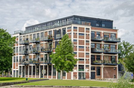 Foto de Enschede, Países Bajos, 9 de agosto de 2023: antigua fábrica textil en el barrio de Roombeek convertida en escuela y espacio de exposición con apartamentos - Imagen libre de derechos