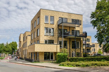 Foto de Enschede, Países Bajos, 9 de agosto de 2023: moderno edificio de apartamentos con fachadas decorativas de ladrillo amarillo en el barrio de Roombeek - Imagen libre de derechos