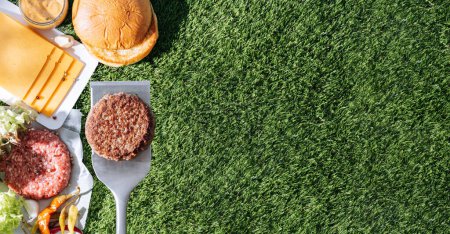 Téléchargez les photos : Barbecue burger cutlet. barbeque concept in nature. barbecue spatula with a burger patty on it - en image libre de droit