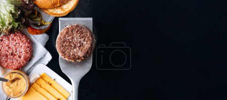 Téléchargez les photos : Barbecue burger cutlet. barbeque concept in nature. barbecue spatula with a burger patty on it - en image libre de droit
