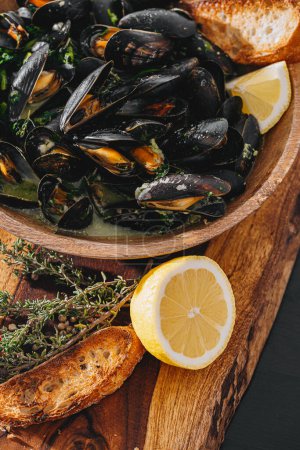 Téléchargez les photos : Boiled mussels with parsley, spinach, Asian herbs and lemon and toasted baguette - en image libre de droit