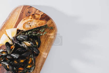 Photo for Boiled mussels with parsley, spinach, Asian herbs and lemon and toasted baguette - Royalty Free Image