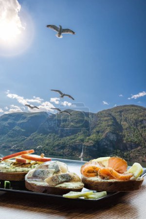 Photo for Typical Scandinavian sandwiches against fjord with seagulls near the Flam village in Norway - Royalty Free Image