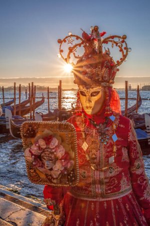 Téléchargez les photos : Colorful carnival mask against gondolas at a traditional festival in Venice, Italy - en image libre de droit