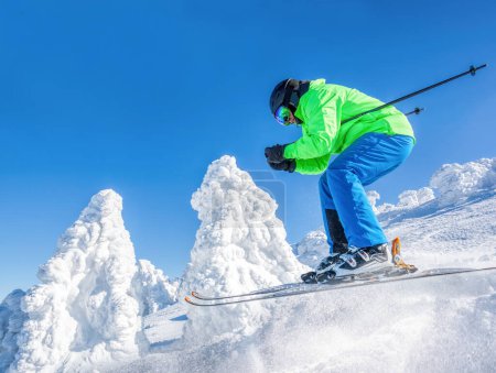Foto de Skier skiing downhill in high mountains against against the fairytale winter forest. - Imagen libre de derechos
