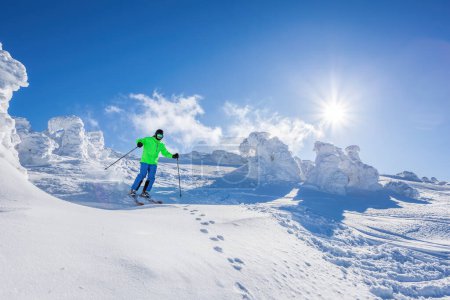 Foto de Skier skiing downhill in high mountains against against the fairytale winter forest. - Imagen libre de derechos
