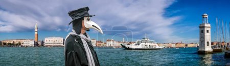 Téléchargez les photos : Célèbre masque de docteur de la peste lors d'un festival traditionnel de carnaval avec panorama de Venise en Italie - en image libre de droit