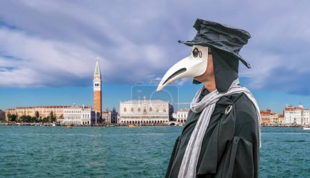 Foto de Famous Plague Doctor Mask at a traditional carnival festival with panorama of Venice in Italy - Imagen libre de derechos