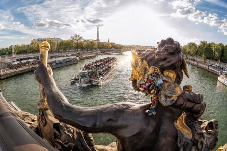 Foto de El Pont Alexandre III (puente) con esculturas contra barco turístico en el Sena y la Torre Eiffel en París, Francia - Imagen libre de derechos