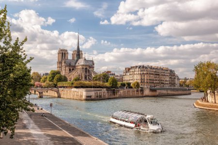 Foto de Catedral de Notre Dame con barco turístico en el Sena durante la primavera en París, Francia - Imagen libre de derechos