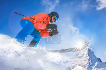 Foto de Esquiador esquiando cuesta abajo en las altas montañas contra el pico Matterhorn en los Alpes suizos - Imagen libre de derechos