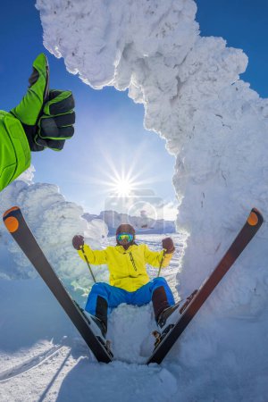 Foto de Esquiador se divierte durante hermosos paisajes de invierno en las altas montañas con los pulgares hacia arriba contra la puesta de sol. - Imagen libre de derechos