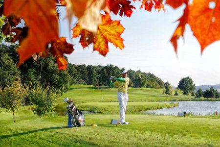 Téléchargez les photos : Homme jouant au golf pendant l'automne coloré - en image libre de droit