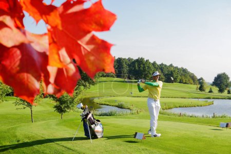 Téléchargez les photos : Homme jouant au golf pendant l'automne coloré - en image libre de droit