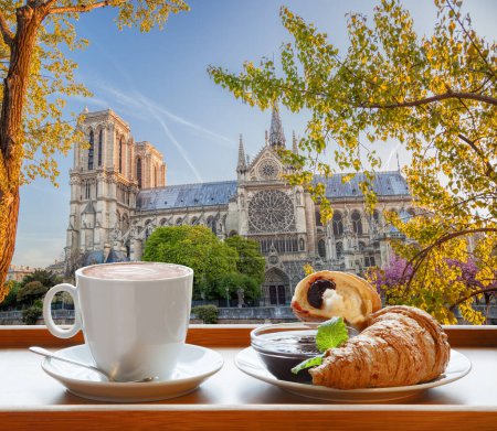 Foto de Café con cruasanes contra la catedral de Notre Dame en París, Francia - Imagen libre de derechos