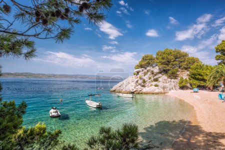 Increíble playa de Punta Rata con barcos contra el mar azul en Brela, Makarska, Dalmacia, costa azul croata
