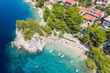 Aerial view of Punta Rata beach with boats and azure sea in Brela, Croatia, Dalmatia, Croatian azure coast