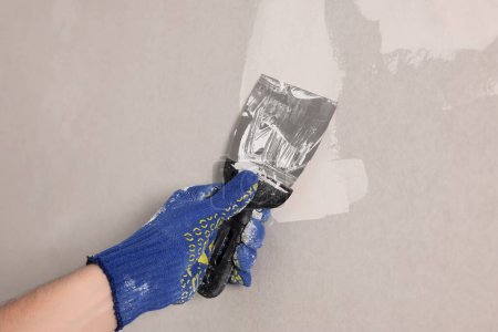 Téléchargez les photos : Ouvrier mur de plâtrage avec couteau à mastic à l'intérieur, gros plan - en image libre de droit
