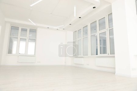 Moderna sala de oficina con paredes y ventanas blancas. Diseño de interiores