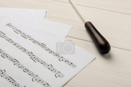 Foto de Bastón de director y partitura sobre mesa de madera blanca - Imagen libre de derechos