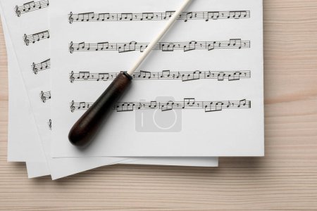 Foto de Bastón de director y partitura en mesa de madera blanca, vista superior - Imagen libre de derechos