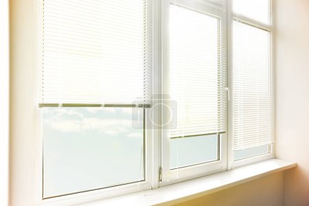 Elegante ventana con persianas horizontales en la habitación