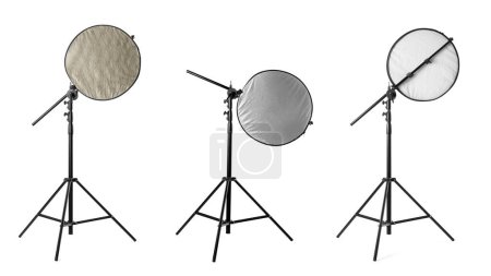 Stative mit verschiedenen Reflektoren auf weißem Hintergrund. Ausrüstung für professionelle Fotografen