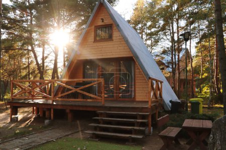 Foto de Pintoresca vista de la casa de madera moderna con veranda cerca del bosque en el día soleado - Imagen libre de derechos